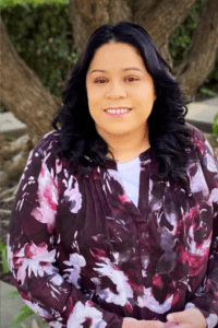 woman wearing a floral shirt posing for a picture