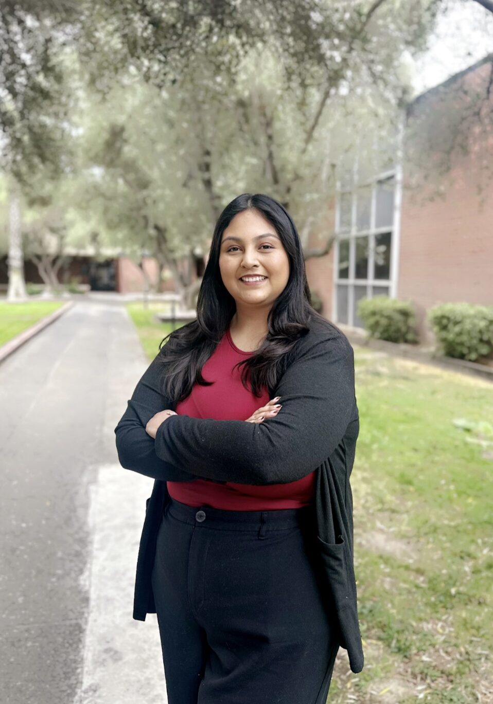 Smiling woman standing outdoors on campus walkway