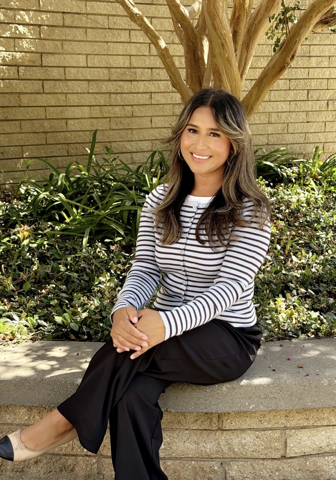 Smiling woman sitting on outdoor stone bench